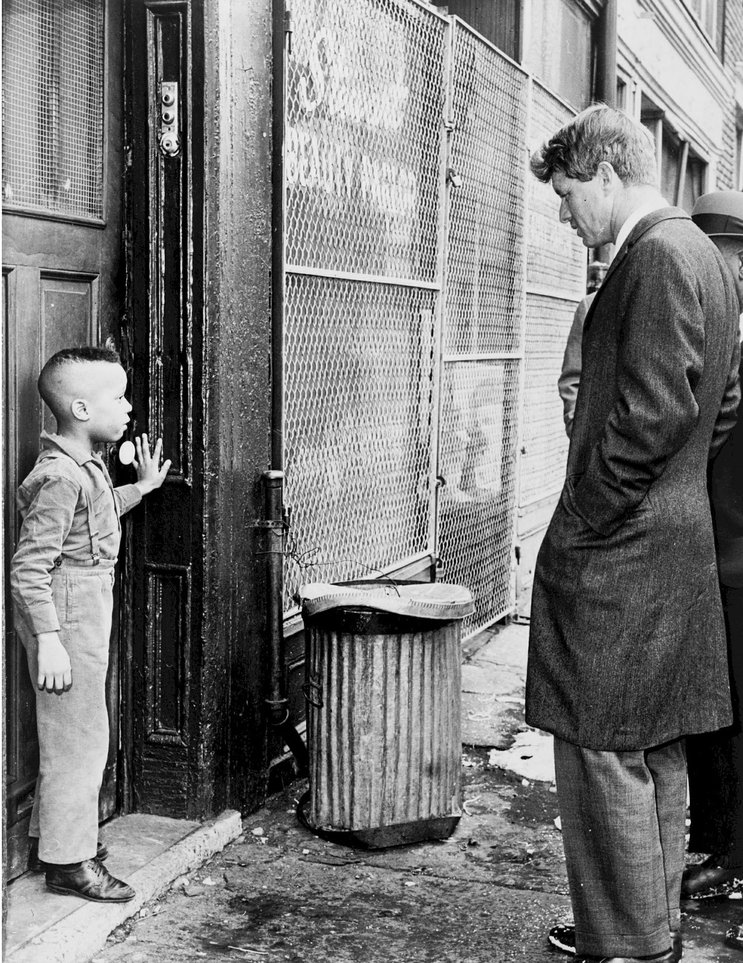 Robert Kennedy talking to young boy in the street.