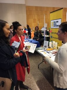 Molly Adams (R) of the Million Meal Movement speaks with students about volunteer opportunities.