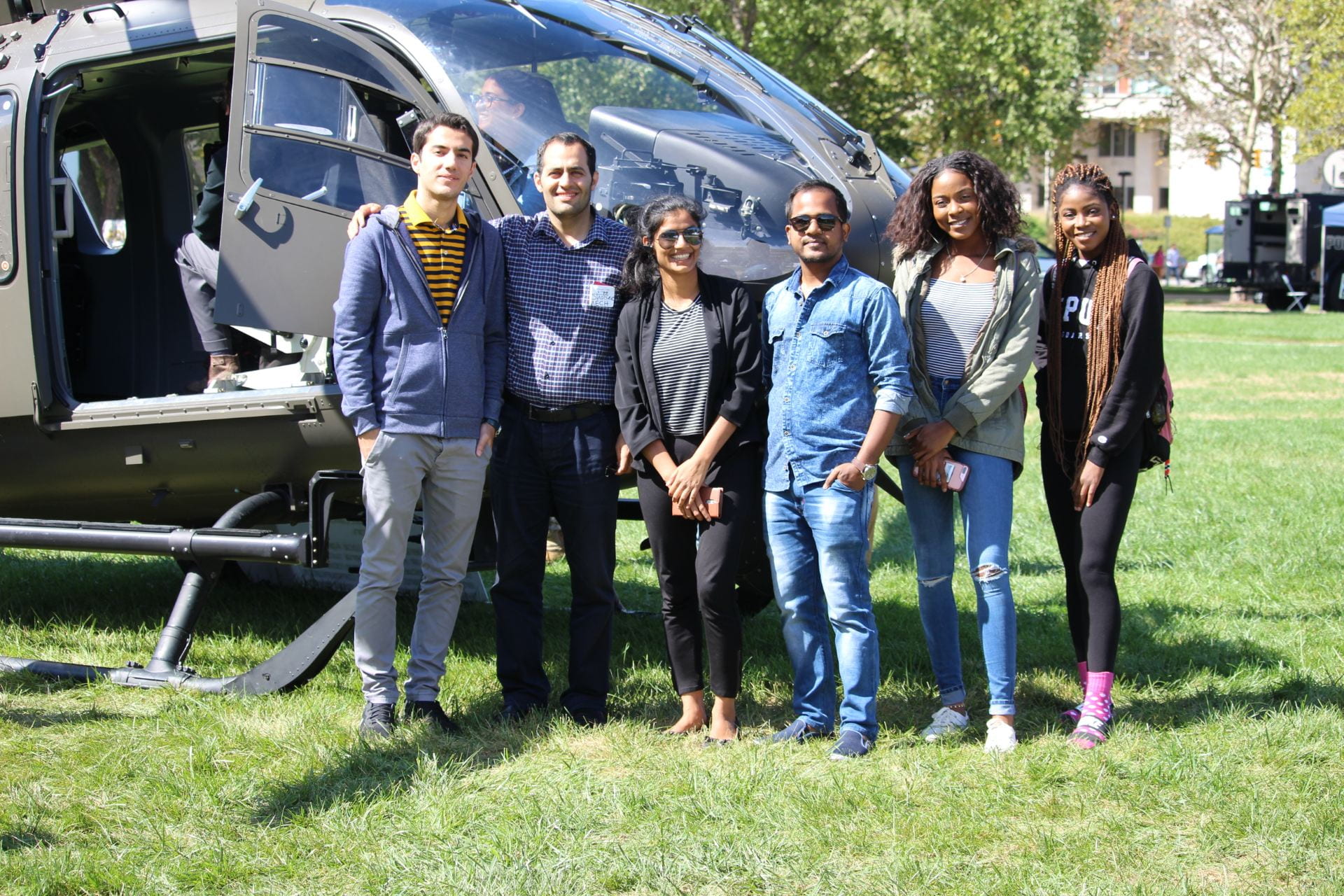 Students stand in front of a military helicopter during Public Safety Career Day 2018.