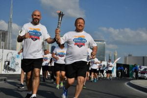 Scott Teal runs through the streets of Abu Dhabi carrying the torch for the Special Olympics' Law Enforcement Torch Run in 2019.
