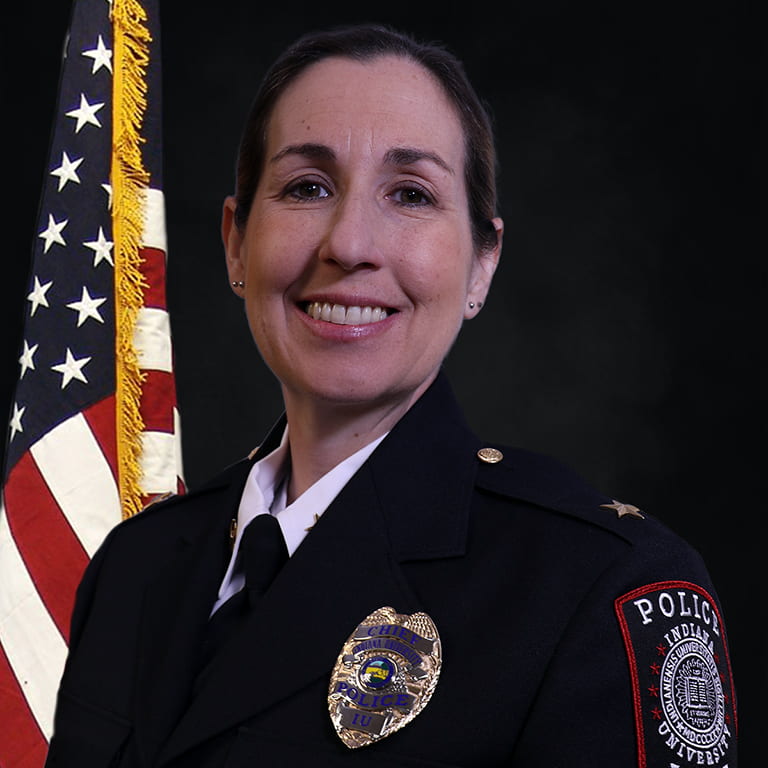 Professional photo of IUPD Police Chief Jill Lees in her uniform, American flag behind.