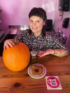 photo of harper morgan at coffee shop counter with pumpkin, bread, and jar of jelly