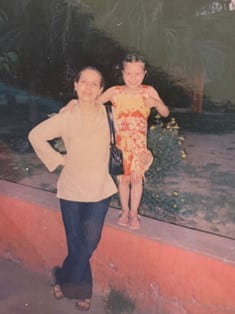 Old photo of woman standing next to her young daughter.