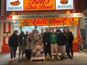 A group of young people stand in front of Ben's Chili Bowl in Washington, D.C.