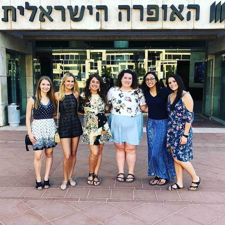 A group of women stand in front of a building in Israel during their study abroad trip.