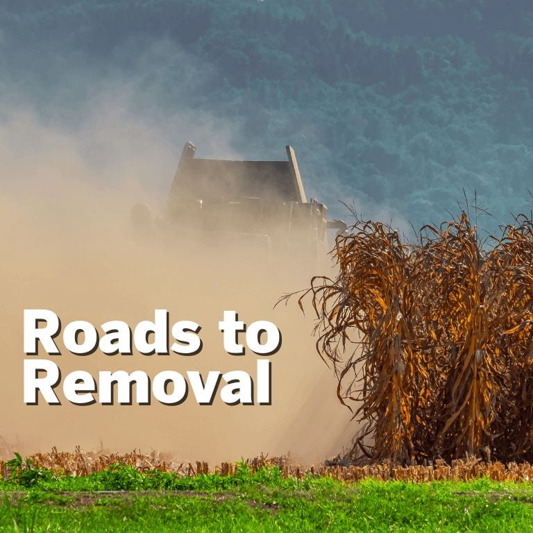 Graphic of combine harvesting corn with the text Roads to Removal overlaid on the image.